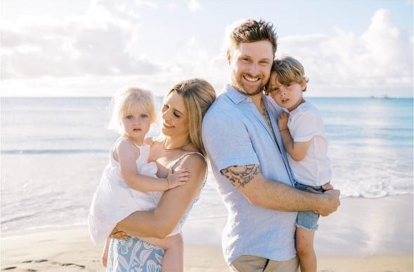 John and Layla, founders of Swept Up Cleaning Co., with their two children on the beach