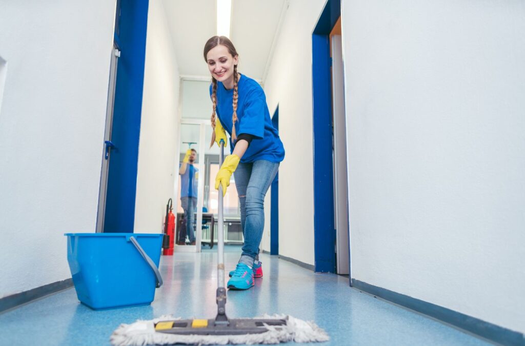 Commercial cleaner using professional tools to sanitize high-touch surfaces in active office space